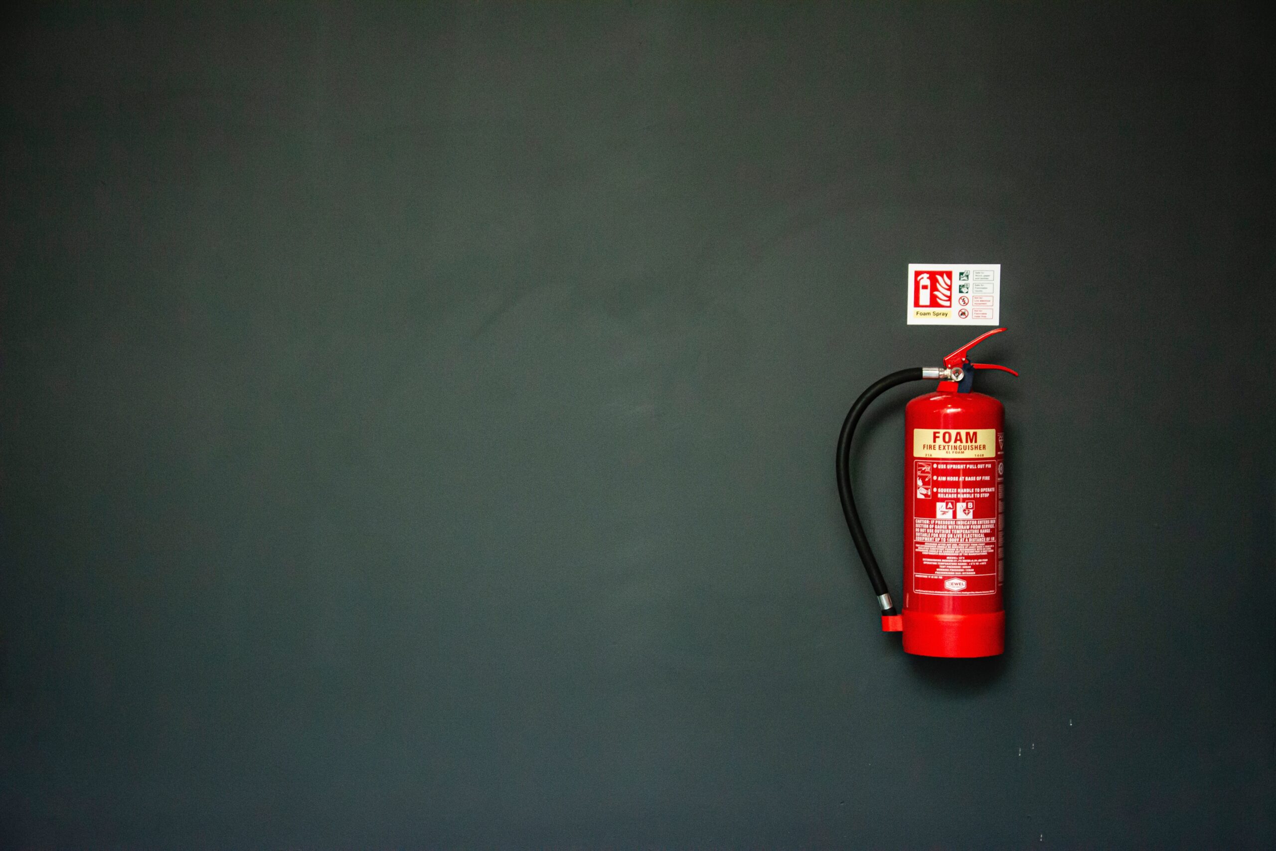 Roter Feuerloescher an einer Wand