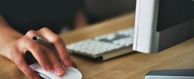 Person vor Computer mit Hand an der Maus - Beitrag Sicherheitslücken fremde Rechner